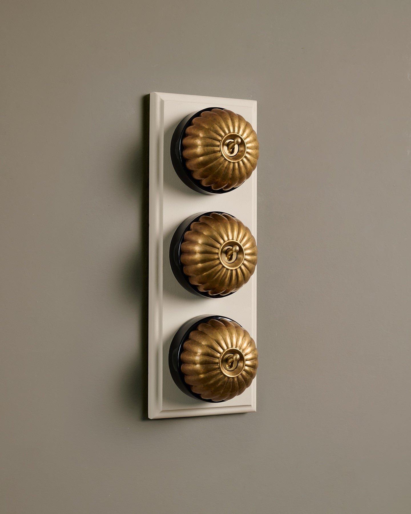 The Jelly Toggle Switch (3 Gang & Primed Maple Pattress) - Aged Brass with Black Base.