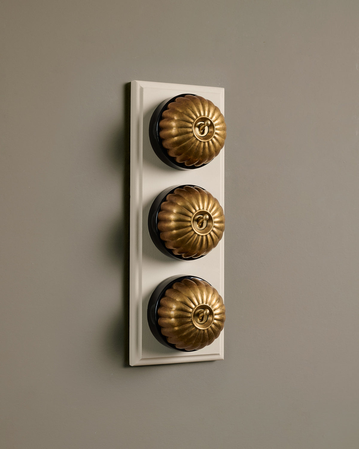 The Jelly Toggle Switch (3 Gang & Primed Maple Pattress) - Aged Brass with Black Base. TEST