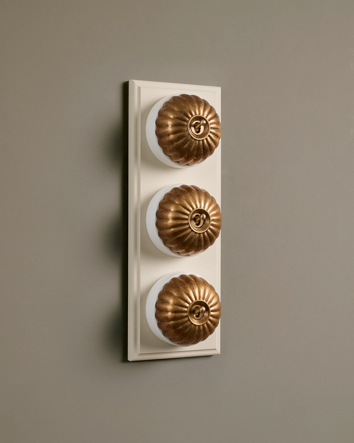 The Jelly Toggle Switch (3 Gang & Primed Maple Pattress) - Aged Brass with White Base. TEST
