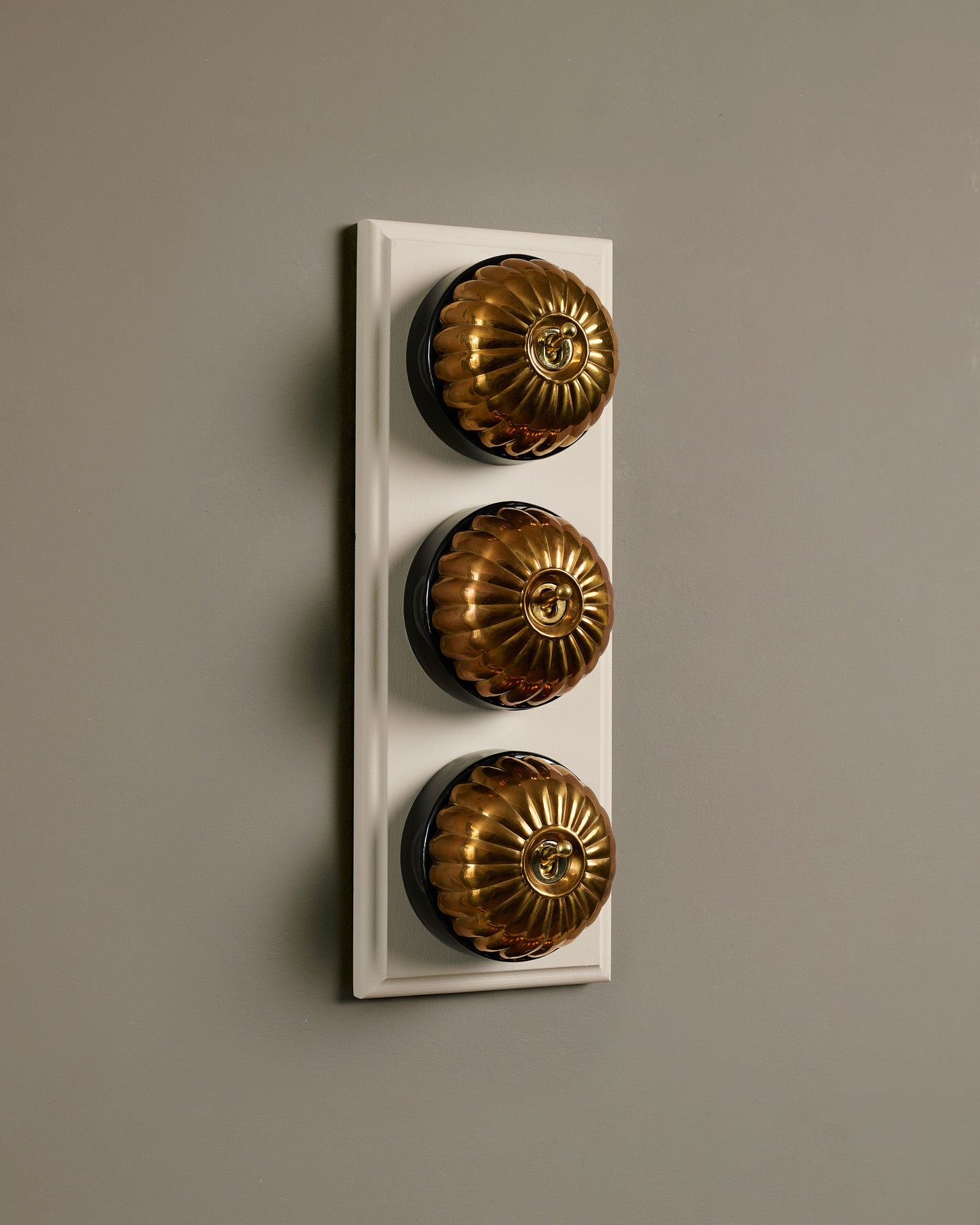 The Jelly Toggle Switch (3 Gang & Primed Maple Pattress) - Heirloom Brass with Black Base.