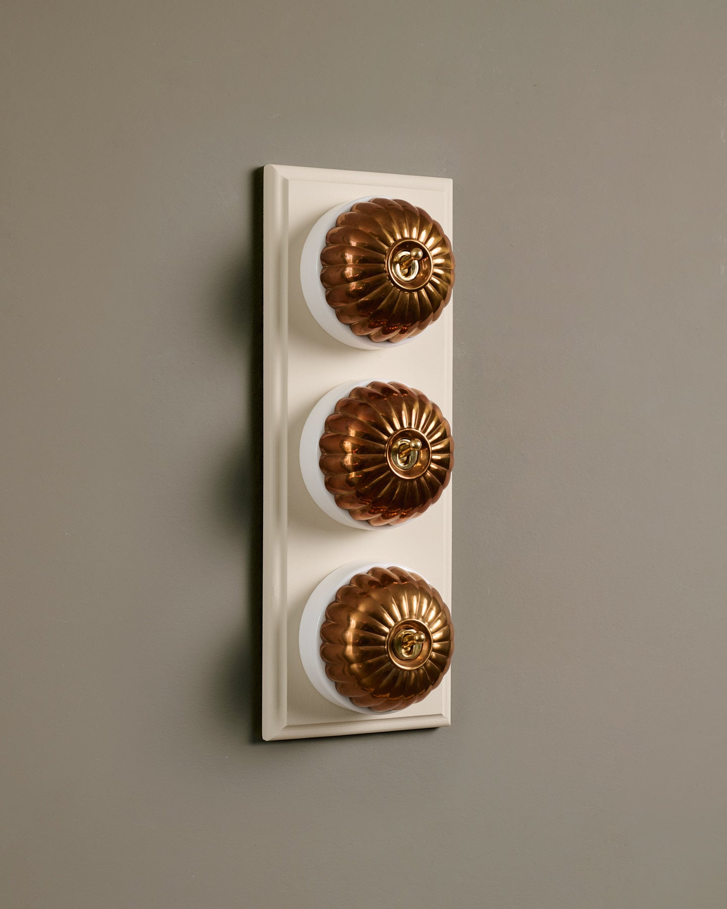 The Jelly Toggle Switch (3 Gang & Primed Maple Pattress) - Heirloom Brass with White Base.
