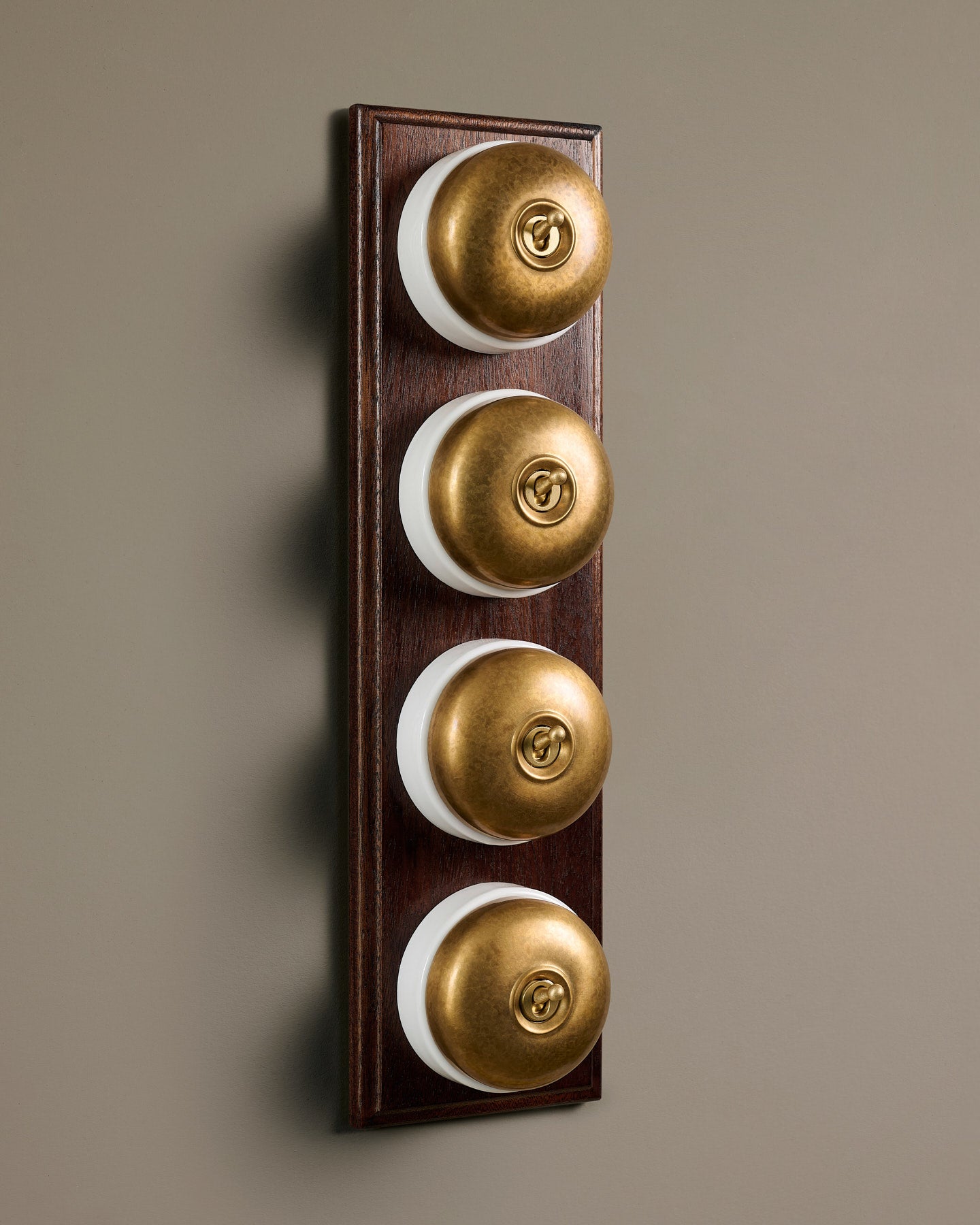 The Dolly Toggle Switch (4 Gang Row & Mahogany Finish Pattress) - Aged Brass with White Base.