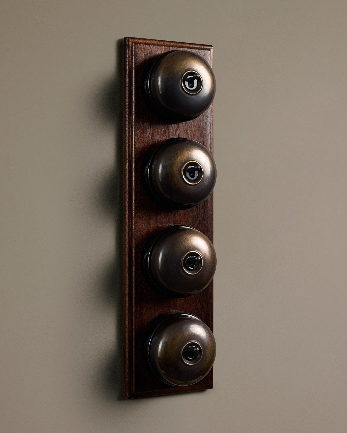The Dolly Toggle Switch (4 Gang Row & Mahogany Finish Pattress) - Oxidised Brass with Black Base.