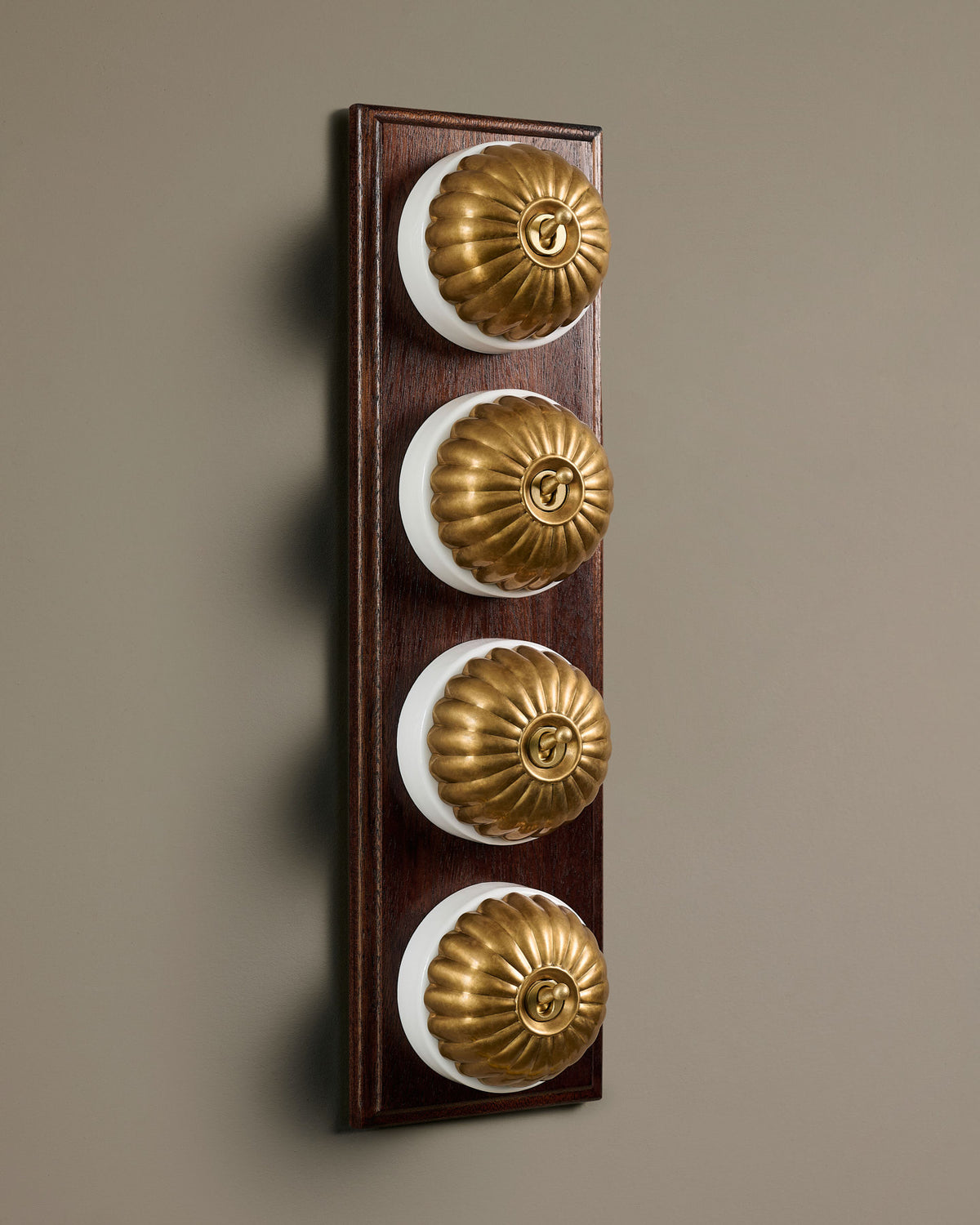 The Jelly Toggle Switch (4 Gang Row & Mahogany Finish Pattress) - Aged Brass with White Base. TEST