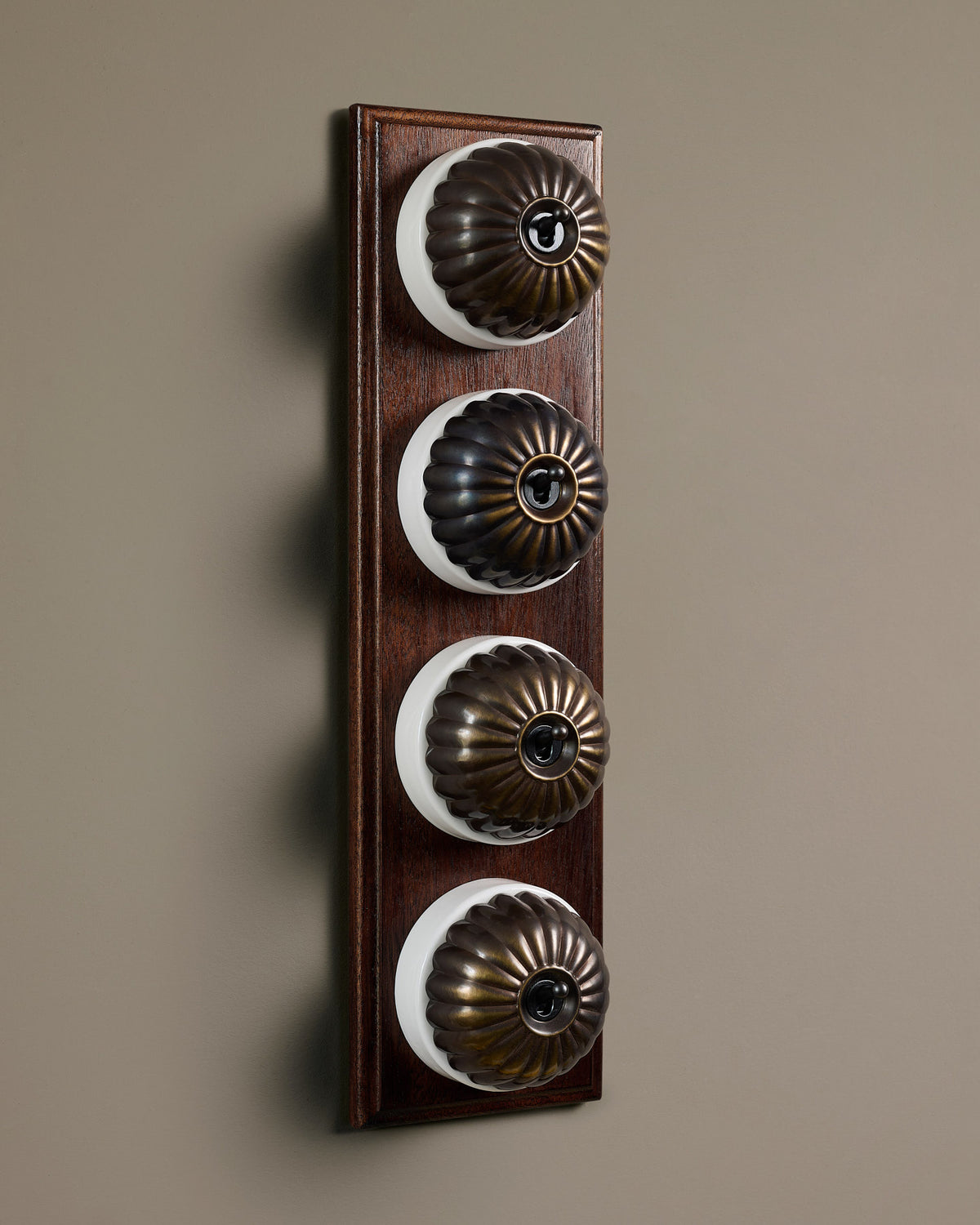 The Jelly Toggle Switch (4 Gang Row & Mahogany Finish Pattress) - Oxidised Brass with White Base. TEST