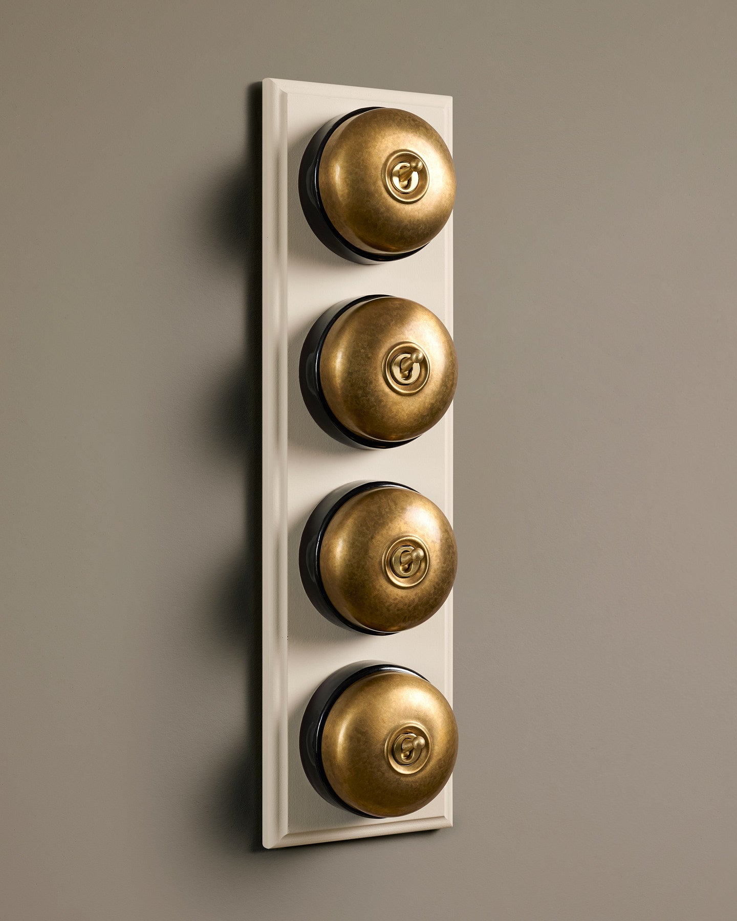 The Dolly Toggle Switch (4 Gang Row & Primed Maple Pattress) - Aged Brass with Black Base.