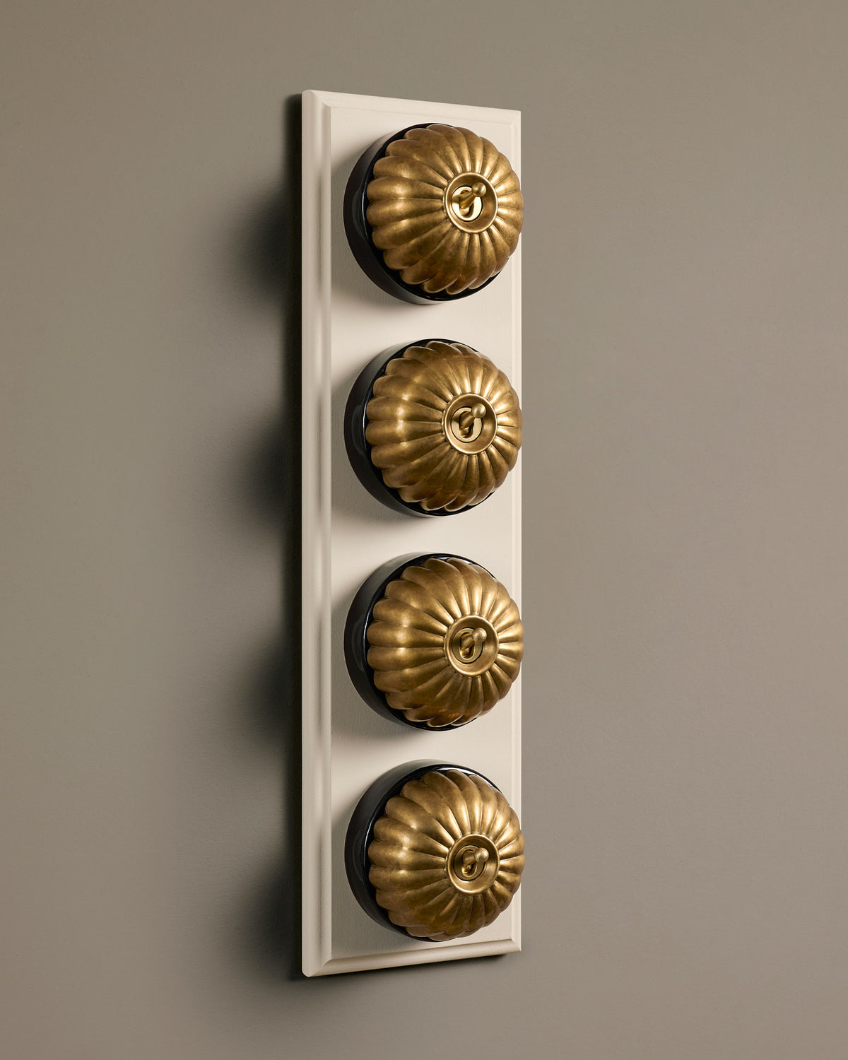 The Jelly Toggle Switch (4 Gang Row & Primed Maple Pattress) - Aged Brass with Black Base. TEST