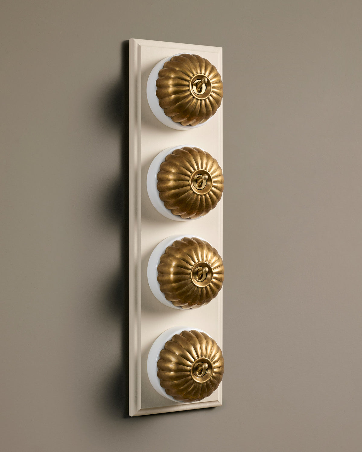 The Jelly Toggle Switch (4 Gang Row & Primed Maple Pattress) - Aged Brass with White Base. TEST