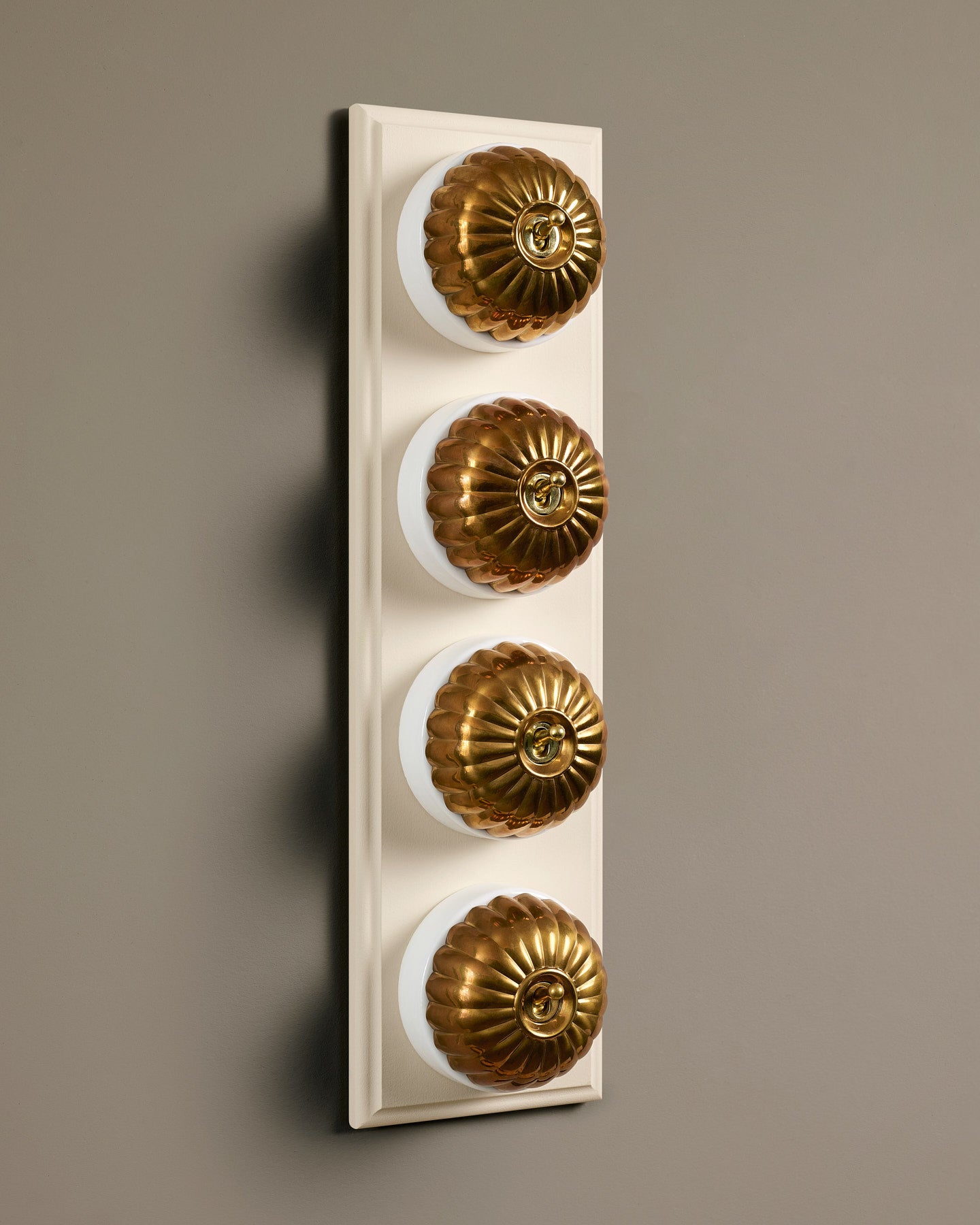 The Jelly Toggle Switch (4 Gang Row & Primed Maple Pattress) - Heirloom Brass with White Base.