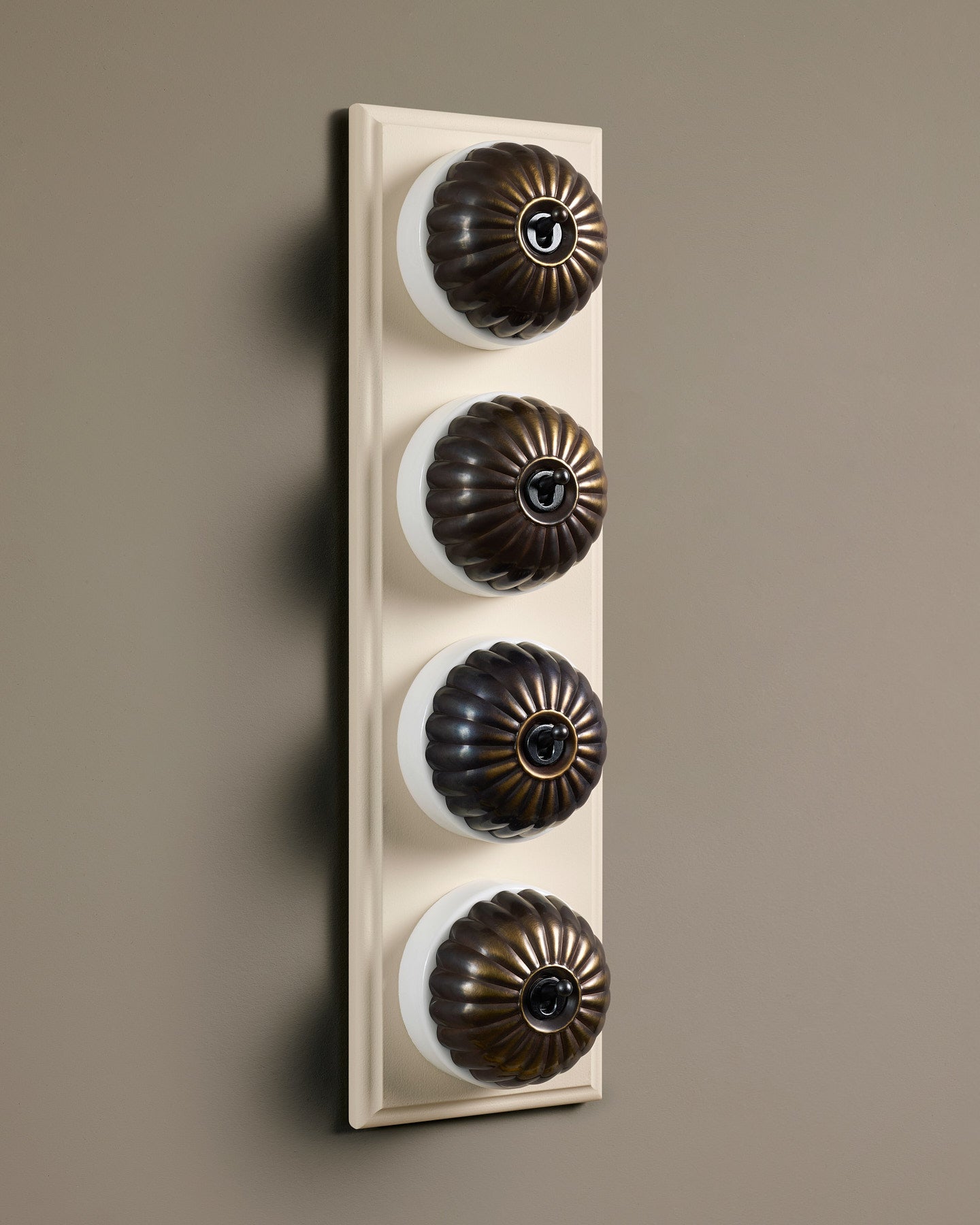 The Jelly Toggle Switch (4 Gang Row & Primed Maple Pattress) - Oxidised Brass with White Base.