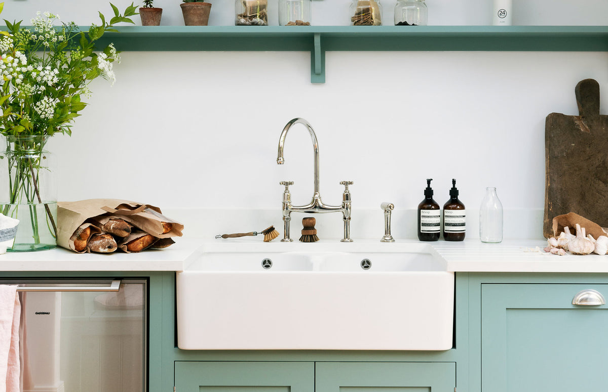 A close-up of a simple trinity blue kitchen featuring a chrome ionian tap.