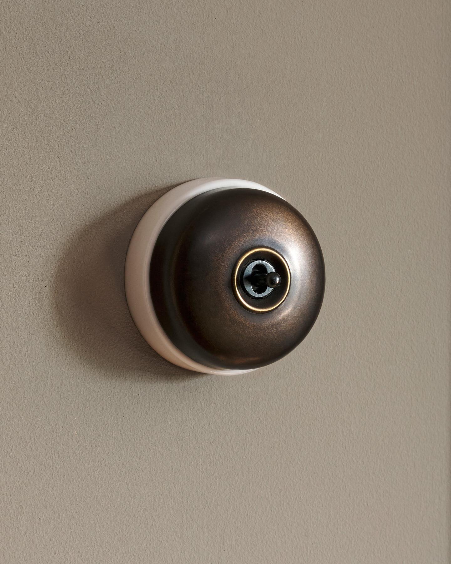 The Dolly Toggle Switch - Oxidised Brass, White Base, Retract to Centre