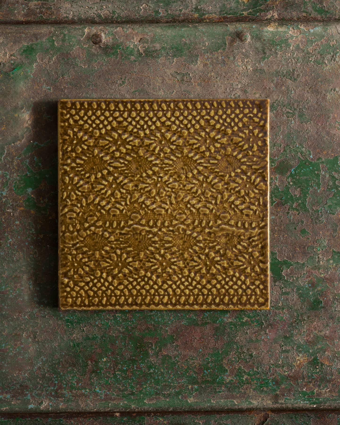 Sepia square with intricate pattern on a textured green surface