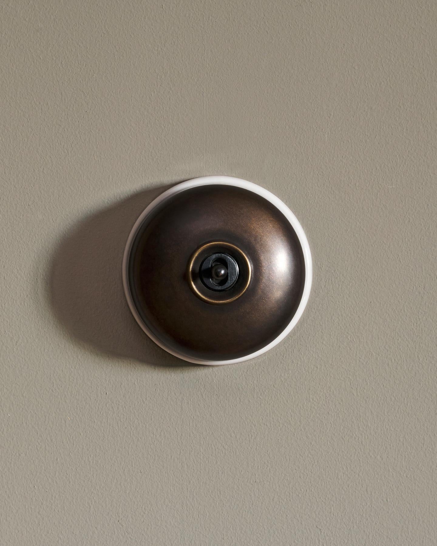The Dolly Toggle Switch - Oxidised Brass, White Base, Retract to Centre