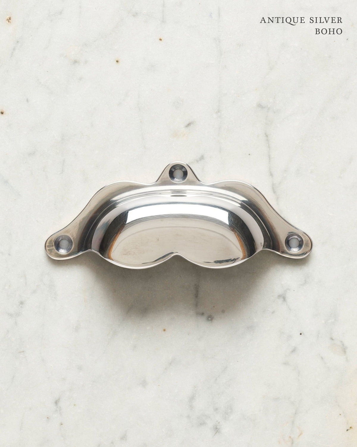 A bohemian-style cup handle for a kitchen cupboard or drawer with a tarnished silver finish. TEST