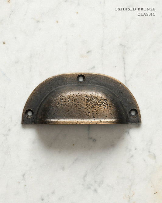 Two classic cup handles for a kitchen cupboard or drawer with a dark oxidised bronze finish. There is a large and a small size.