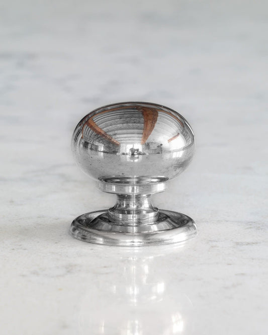 A 'Medium' round doorknob with a pressed backplate for a kitchen cupboard or drawer in a polished chrome finish.