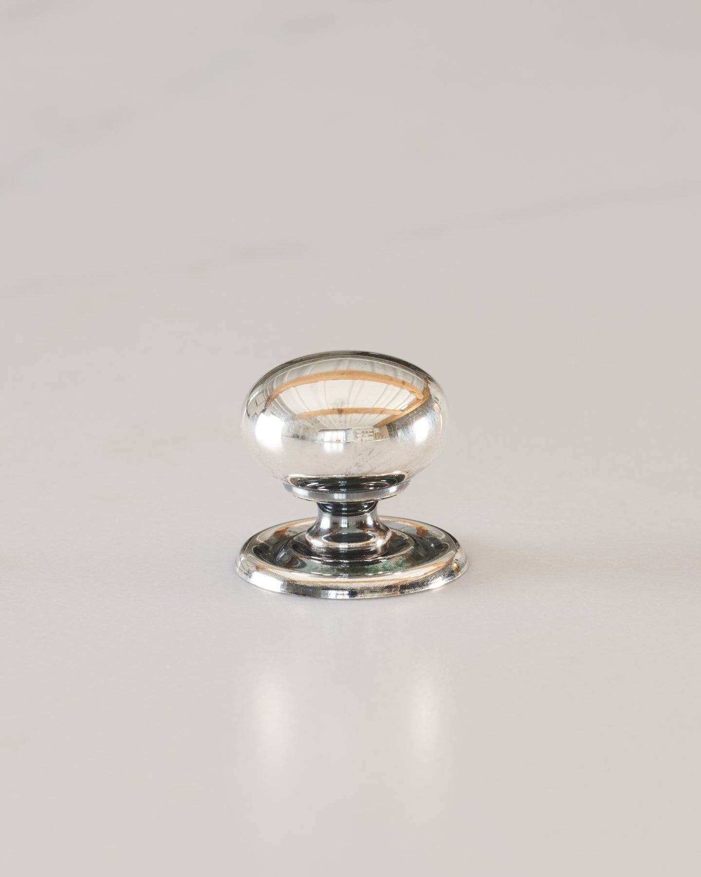 A 'Small' round doorknob with a pressed backplate for a kitchen cupboard or drawer in a tarnished silver finish.