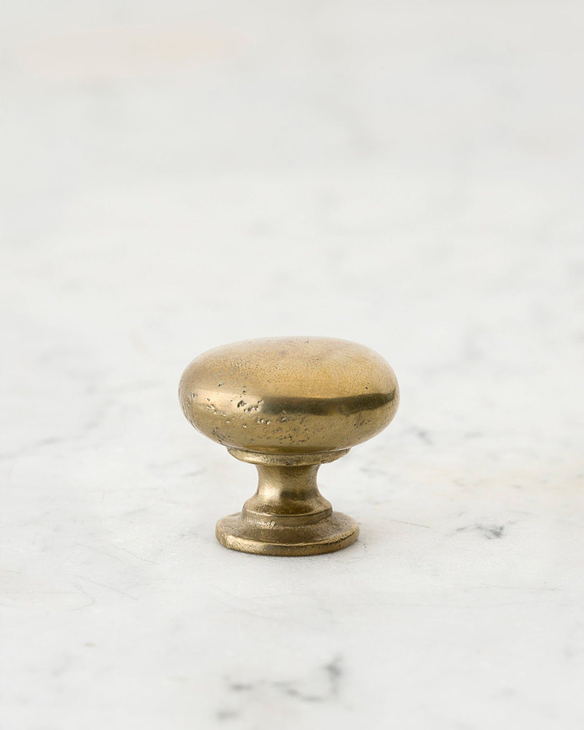 A 'Small' classic knob for a kitchen cupboard or drawer with an aged brass finish and unique dented textures that makes it look like a beloved, well aged brass from centuries ago. TEST