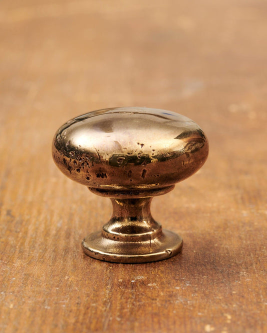 A 'Large' classic knob for a kitchen cupboard or drawer with a warm burnished brass finish and unique dented textures as if was made by an artisan blacksmith centuries ago.