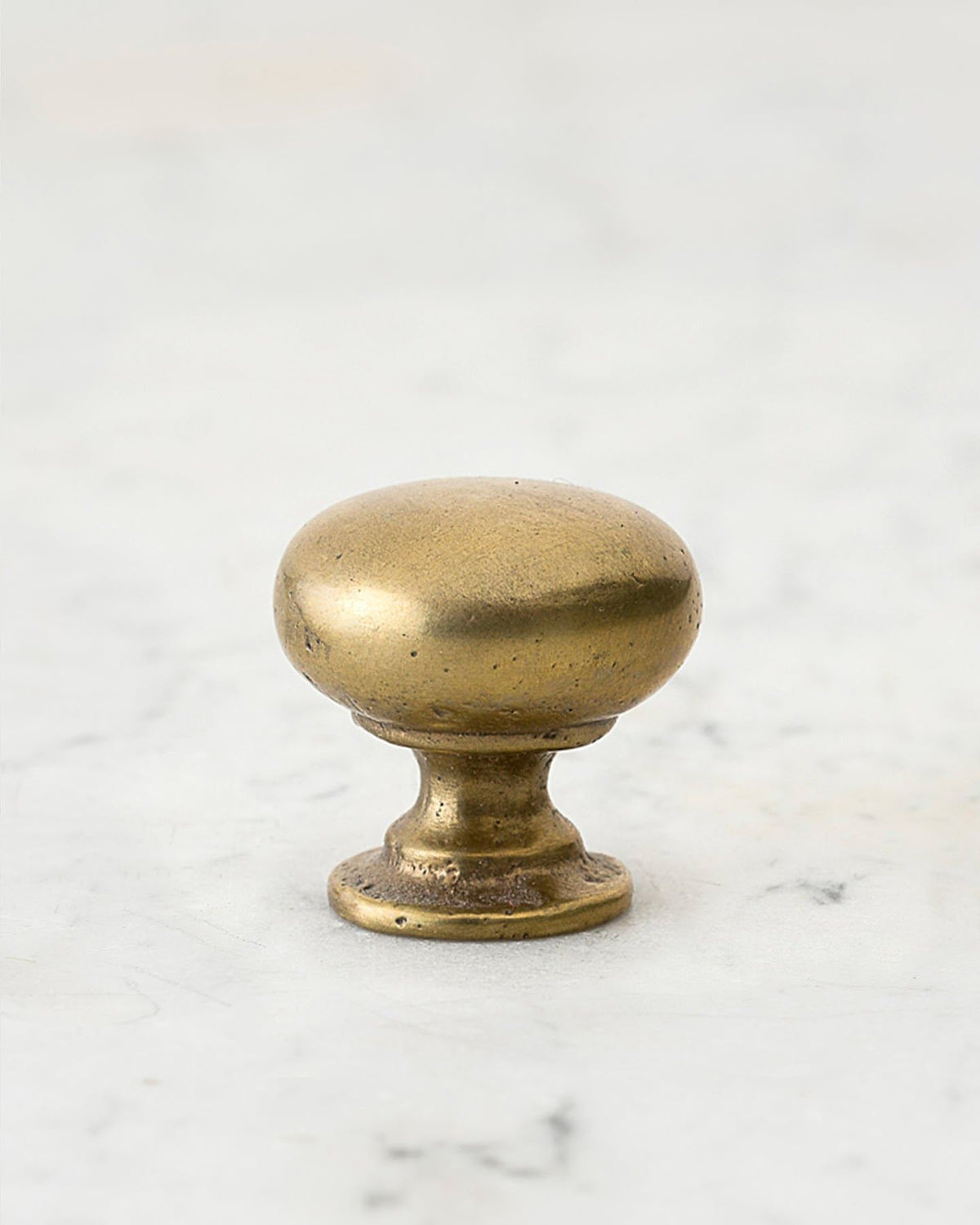 A 'Medium' classic knob for a kitchen cupboard or drawer with an aged brass finish and unique dented textures that makes it look like a beloved, well aged brass from centuries ago. TEST