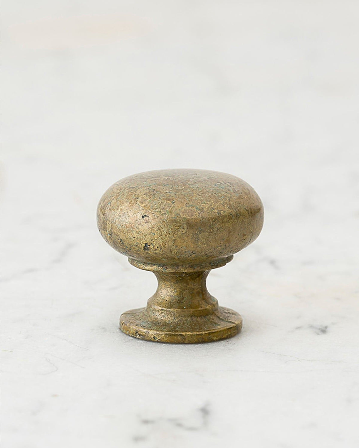 A 'Medium' classic knob for a kitchen cupboard or drawer with an aged verdigris brass finish and unique dented textures as if was made by an artisan blacksmith centuries ago. TEST