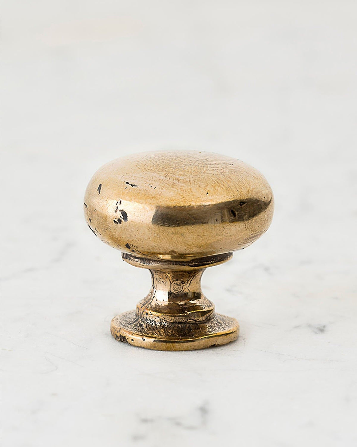 A 'Large' classic knob for a kitchen cupboard or drawer with a bright polished bronze finish and unique dented textures that makes it look like a beloved, well aged bronze from centuries ago. TEST