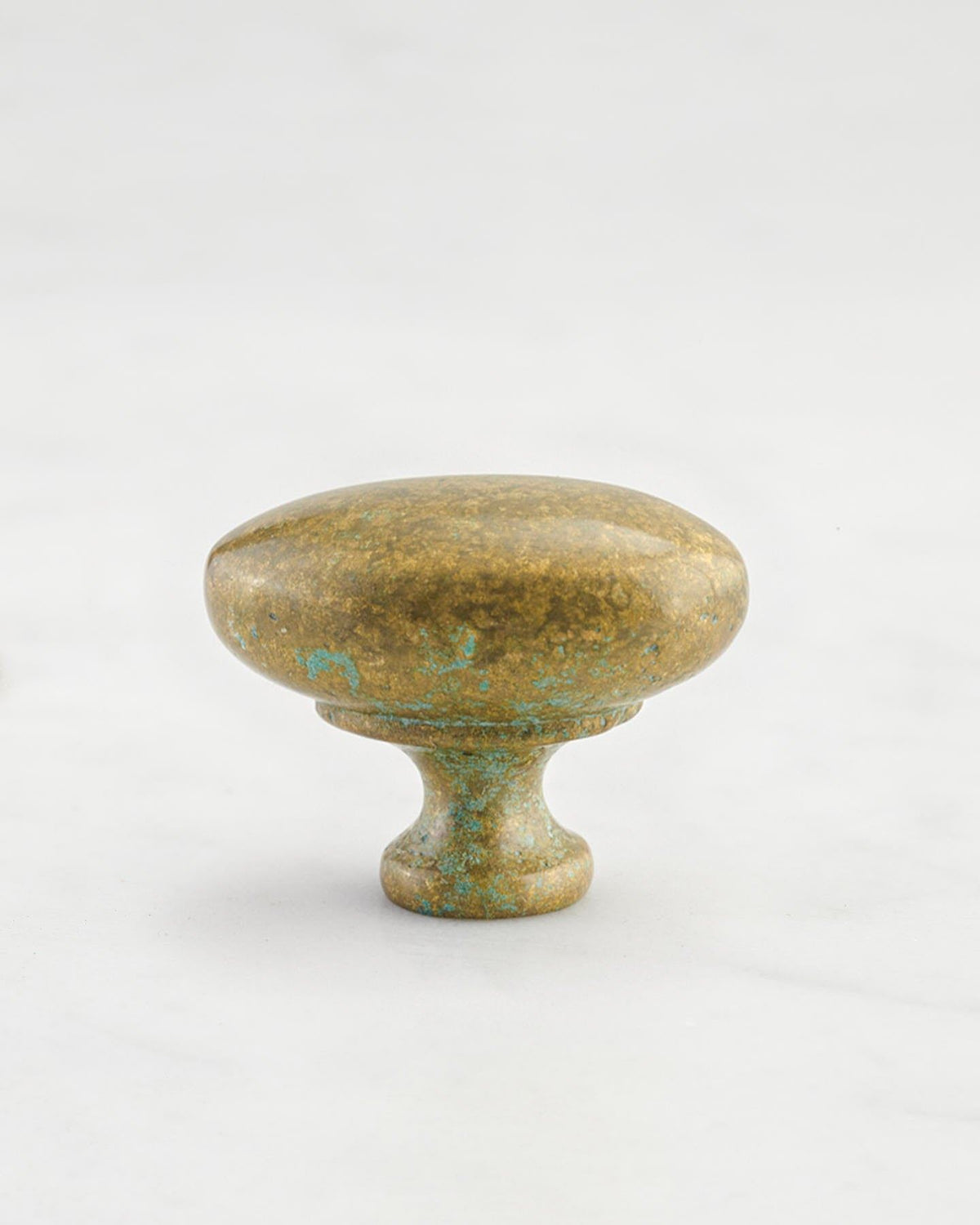 A 'Medium' oval-shaped knob for a kitchen cupboard or drawer with an aged verdigris brass finish and unique dented textures as if was made by an artisan blacksmith centuries ago. TEST