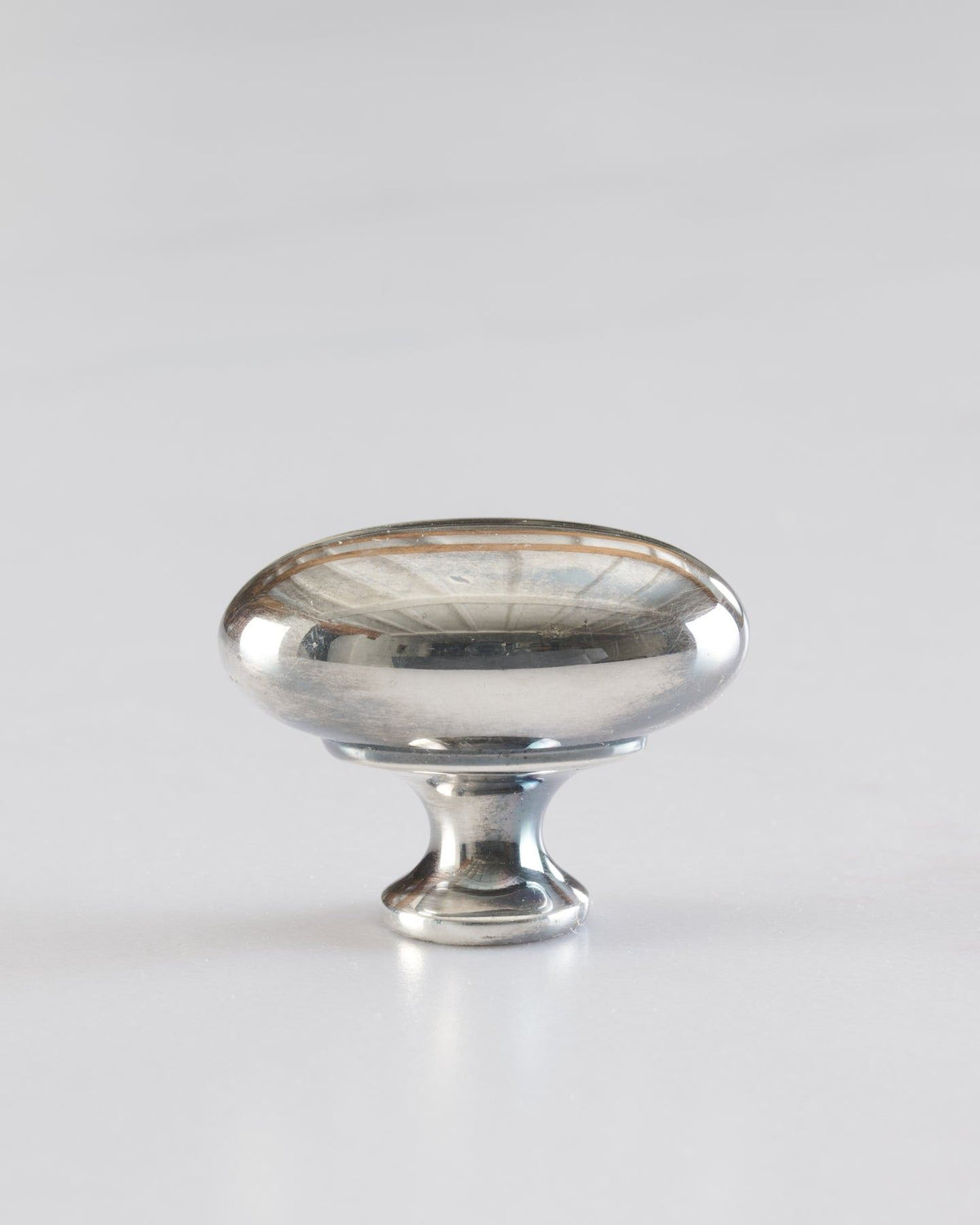 A 'Medium' oval-shaped knob for a kitchen cupboard or drawer with a tarnished silver finish. TEST