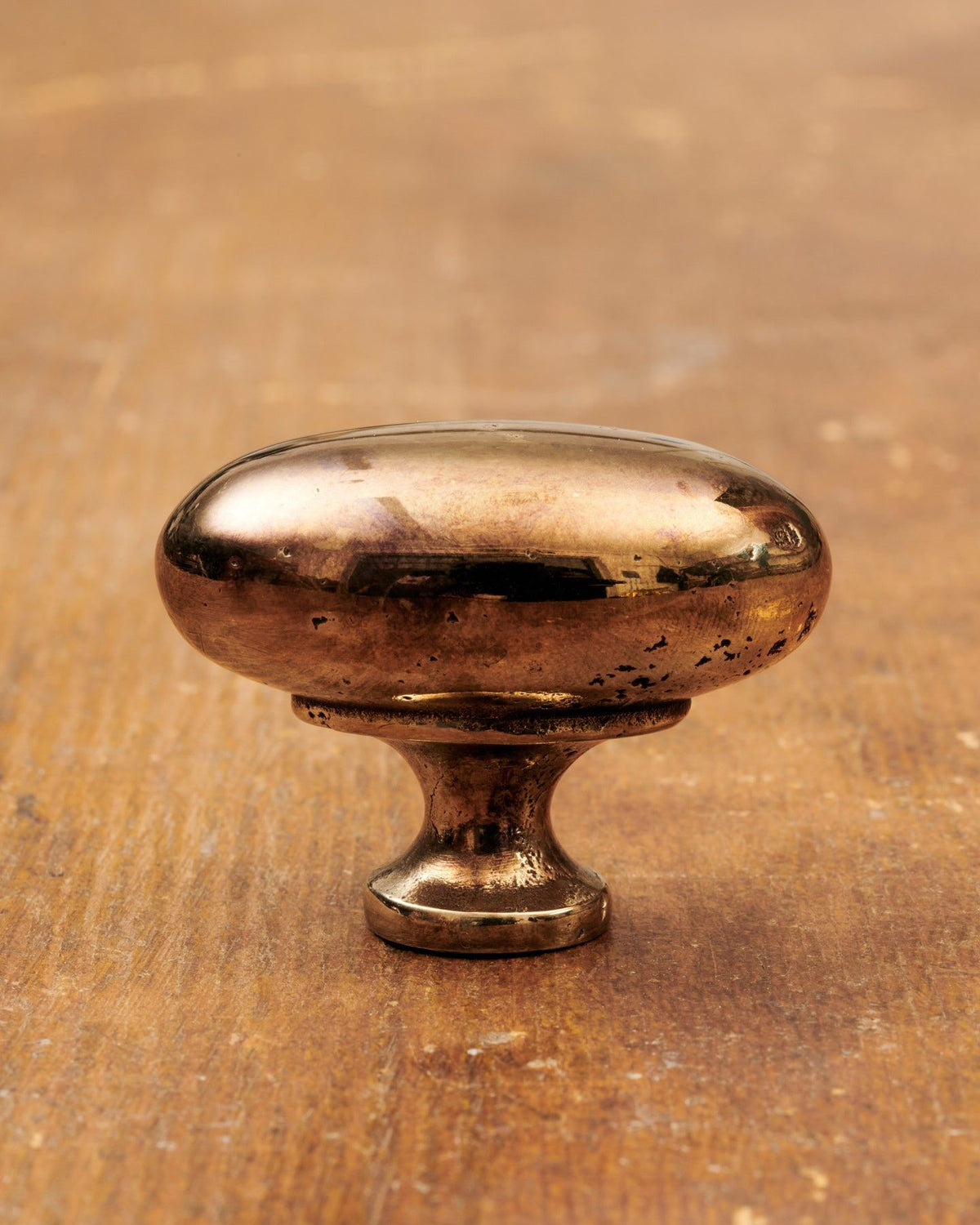 A 'Large' oval-shaped knob for a kitchen cupboard or drawer with a warm burnished brass finish and unique dented textures as if was made by an artisan blacksmith centuries ago. TEST