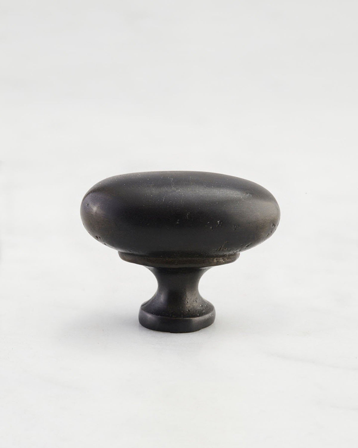 A 'Medium' oval-shaped knob for a kitchen cupboard or drawer with a matt black bronze finish that makes it look like a beloved, well aged brass from centuries ago. TEST