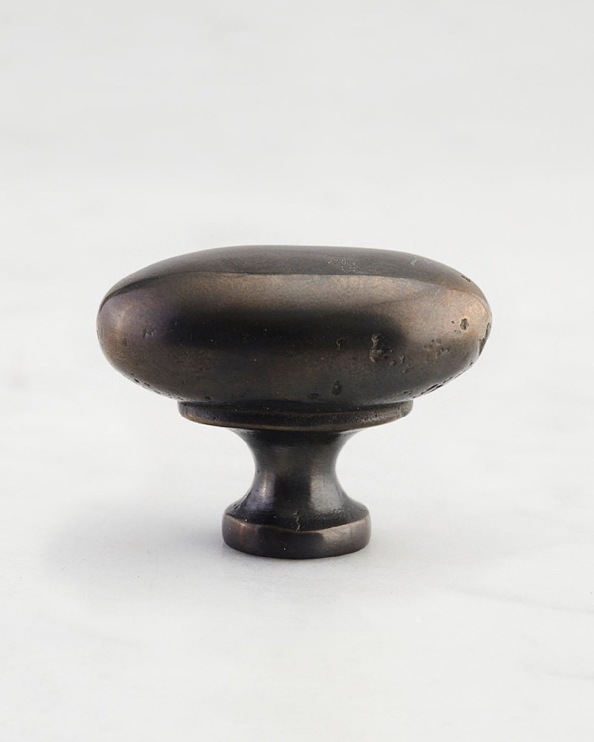 A 'Large' oval-shaped knob for a kitchen cupboard or drawer with a dark oxidised bronze finish  and unique dented textures as if was made by an artisan blacksmith centuries ago. TEST
