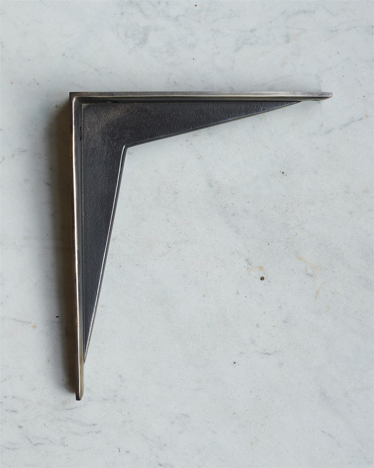 A side profile view of a classic utilitarian shelf bracket in a dark oxidised brass finish. TEST