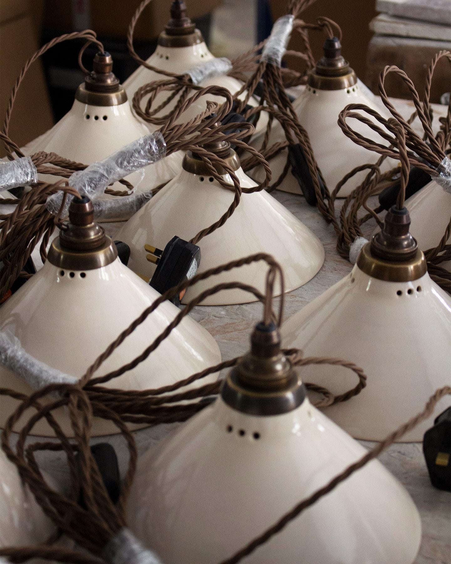 A collection of small plug-in lights with a cream glazed shades, brown twisted fabric flex cord and brass fittings.