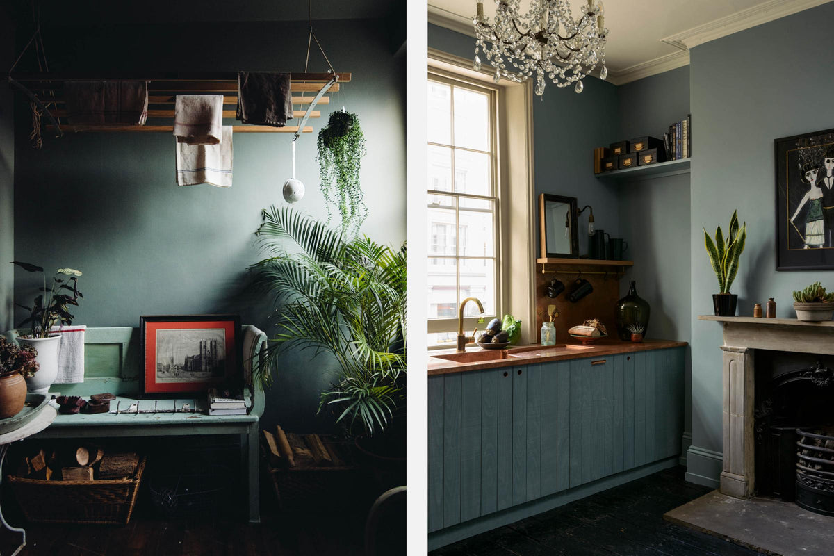 A sweet and simple Clerkenwell blue Sebastian Cox kitchen features a short cooker and sink run with a copper worktop and splashback, a single copper sink, an electric stove and shelves with brass hanging rails. Adorned with artisan ceramics, vintage bric-a-brac, aubergines, hanging plants, a framed quirky illustration, a crystal chandelier, and bare wall lights, this kitchen creates a glamorous and practical space.