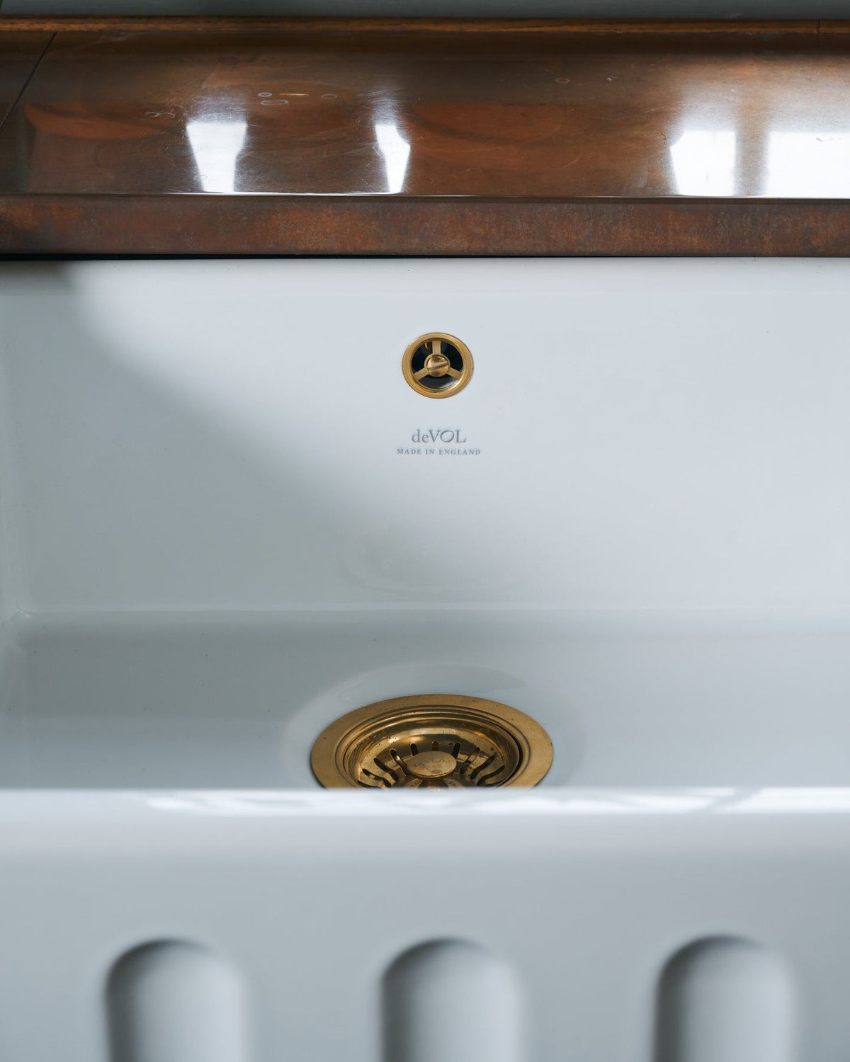 A close-up straight-on view of a fluted ceramic Belfast sink. TEST
