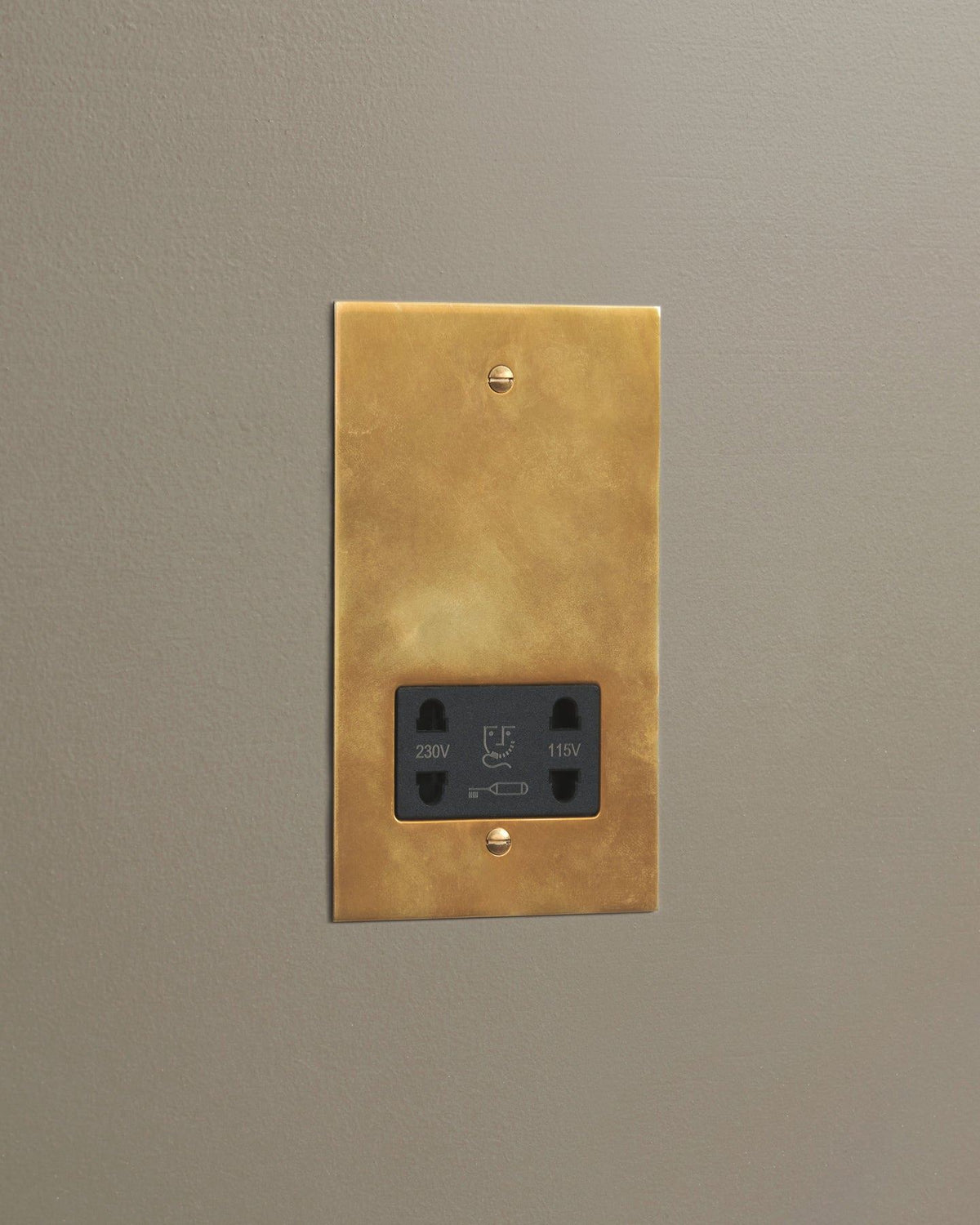 An oblique view of a classic twin shaver socket in a warm burnished brass finish. TEST