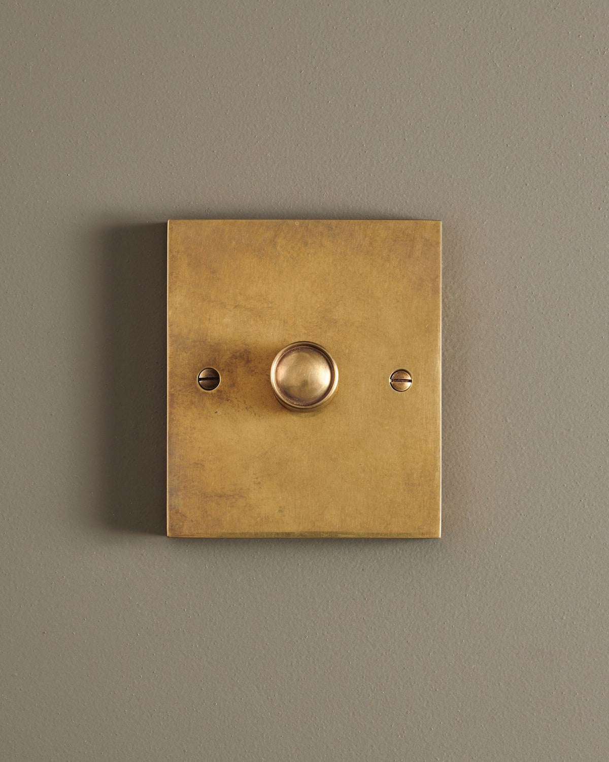 A straight-on view of a 1 gang box dimmer switch in a warm burnished brass finish. TEST