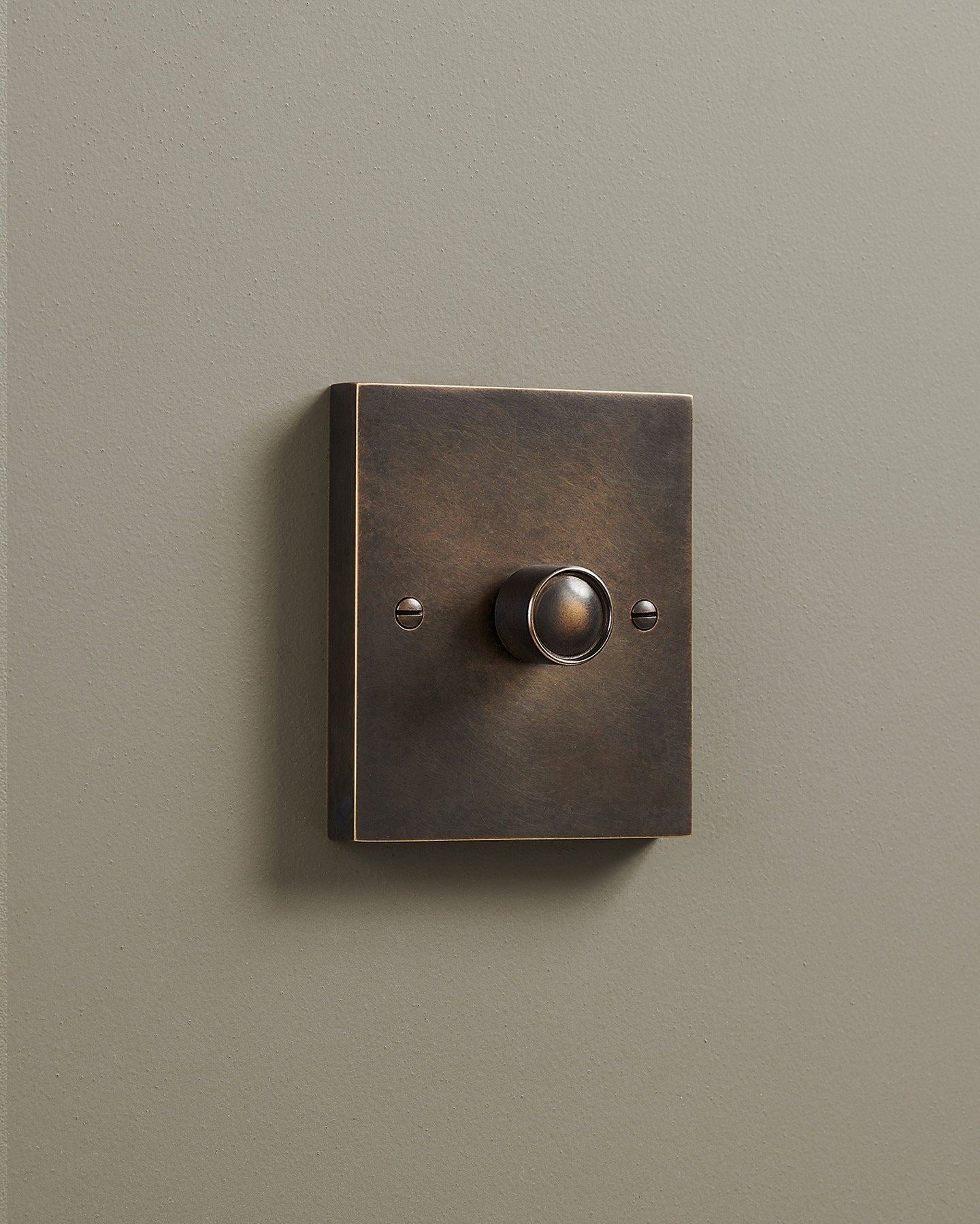 An oblique view of a 1 gang box dimmer switch in a dark oxidised brass finish.