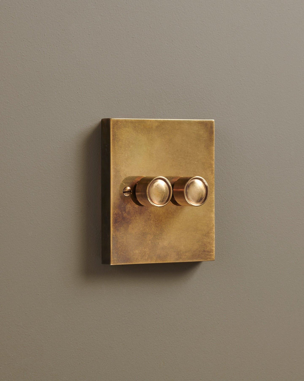 An oblique view of a 2 gang box dimmer switch in a warm burnished brass finish. TEST