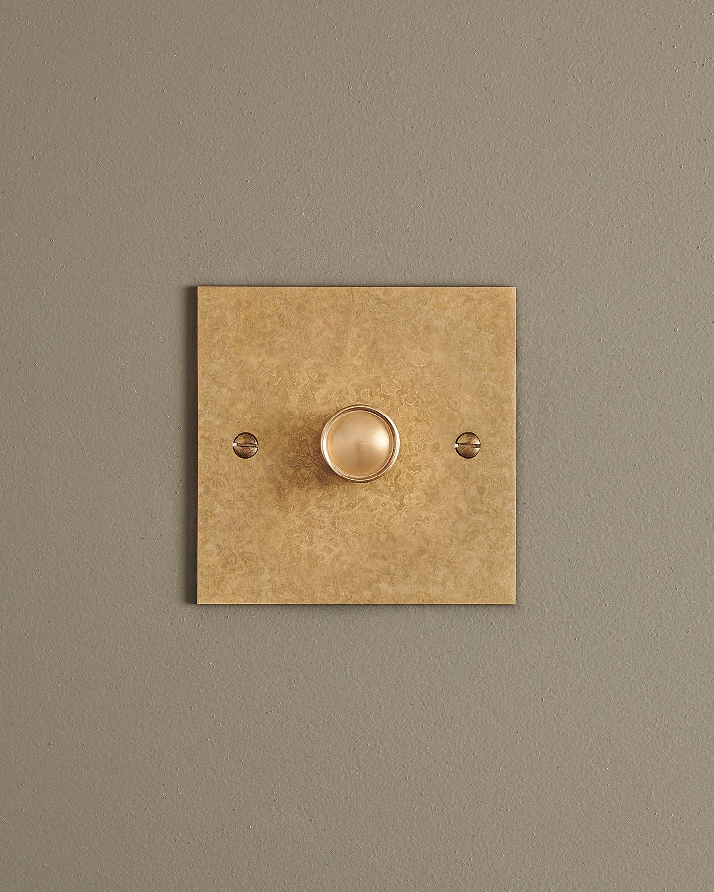 A straight-on view of a 1 gang classic dimmer switch in a mottled aged brass finish.