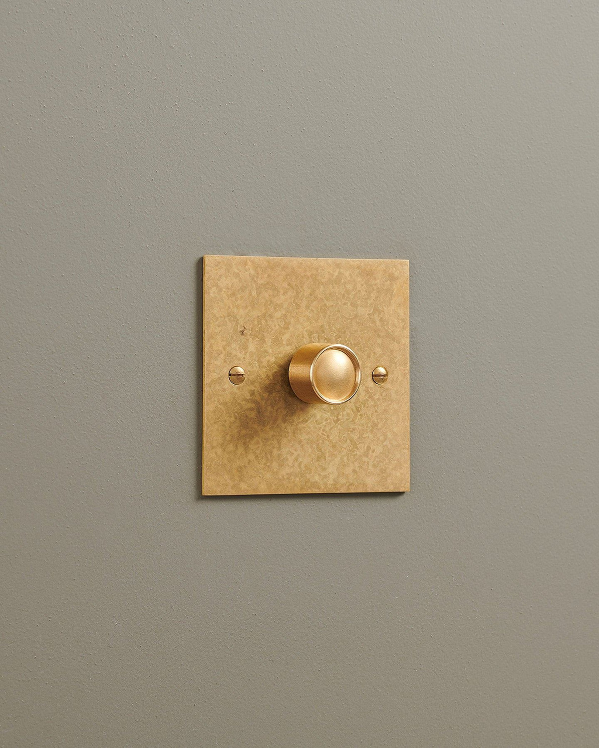 An oblique view of a 1 gang classic dimmer switch in a mottled aged brass finish. TEST
