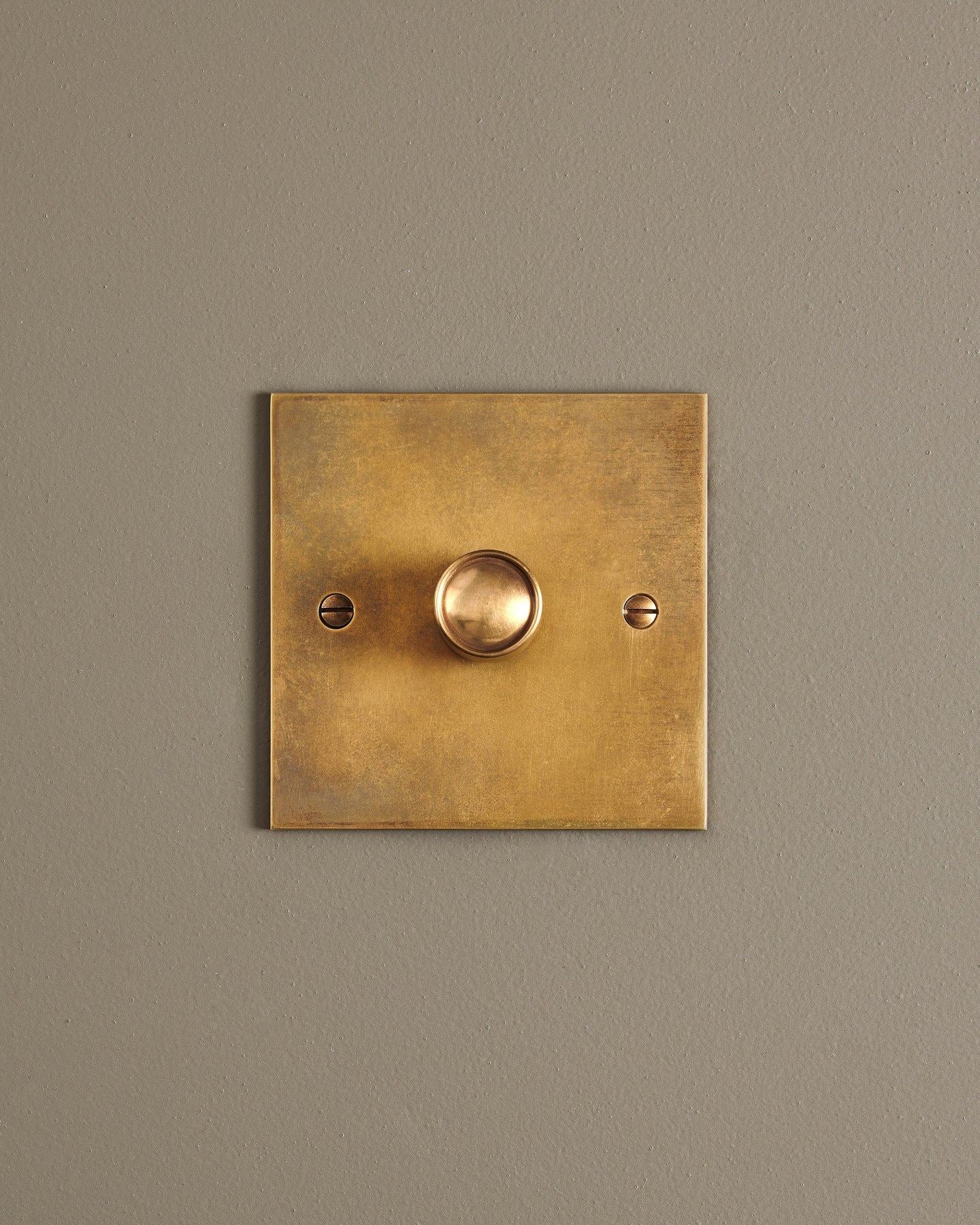 A straight-on view of a 1 gang classic dimmer switch in a warm burnished brass finish.