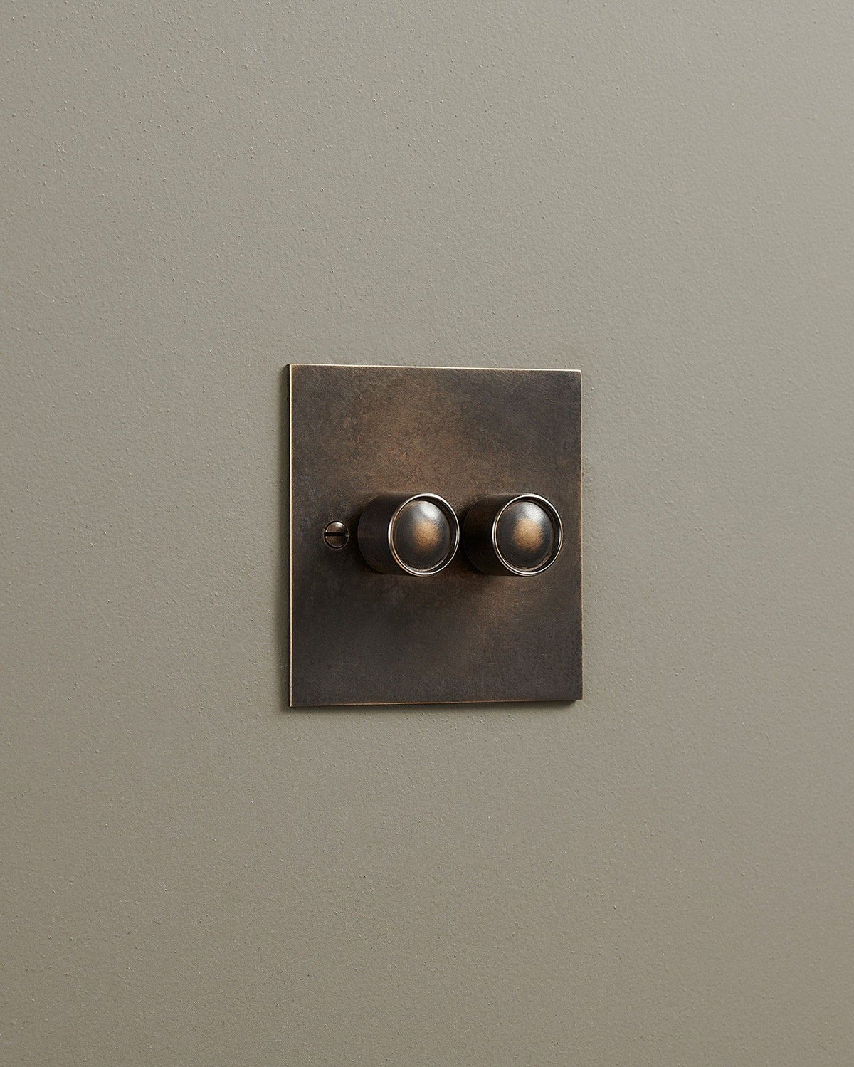 An oblique view of a 2 gang classic dimmer switch in a dark oxidised brass finish. TEST