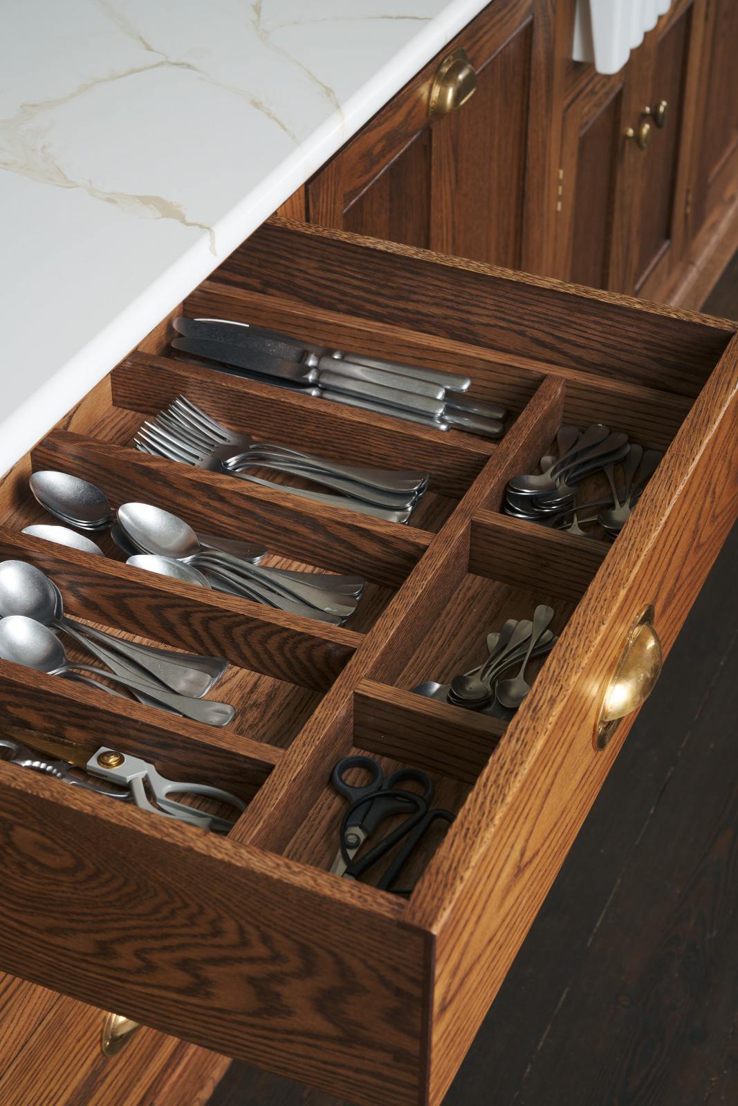 A close-up of a cutlery insert with silver cutlery as part of a bespoke 3.5-metre-long dairy table.
