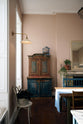 A room of the grandest proportions with pretty pink walls and plenty of vintage furniture. deVOL's Heirloom Task Light sits high up on the wall. It has a long brass arm and a wide ceramic shade, reminiscent of lights in old English country homes.