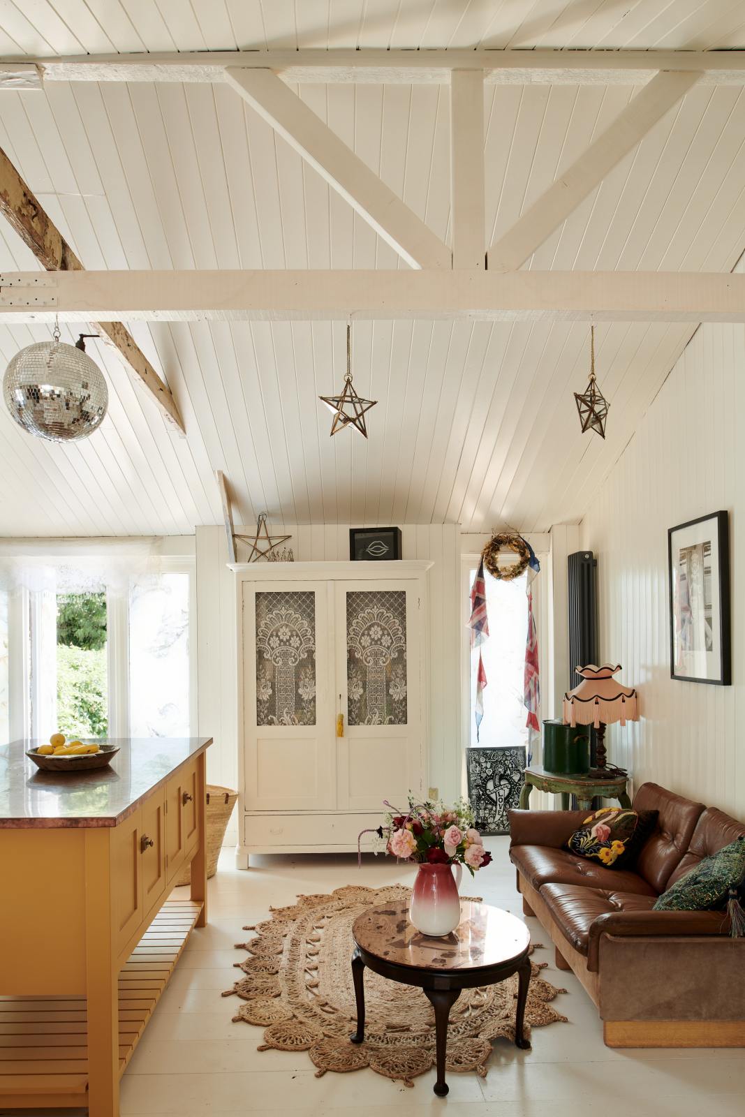 A side of a mustardy yellow prep table sits at the centre of the room, creating a galley-style working area.