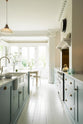 The bright pathway between the cooker and the kitchen island features a double Belfast sink, all part of the Trinity Blue shaker kitchen. In front of this area is a small conservatory with its original French doors, which let in plenty of natural light that fills the pale wooden breakfast table and cushioned chairs.